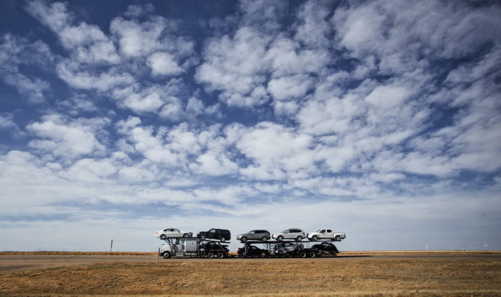 Cars being hauled under blue sky