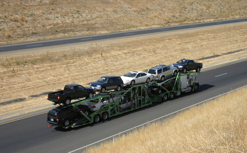 a transport truck on the highway in the midst of terminal-to-terminal auto shipping
