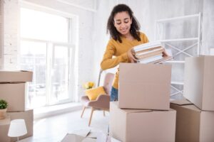 curly-hair college-aged student getting packed up while moving for university