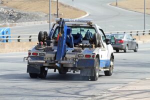 a tow truck, part of the car towing vs. shipping debate, driving on a highway