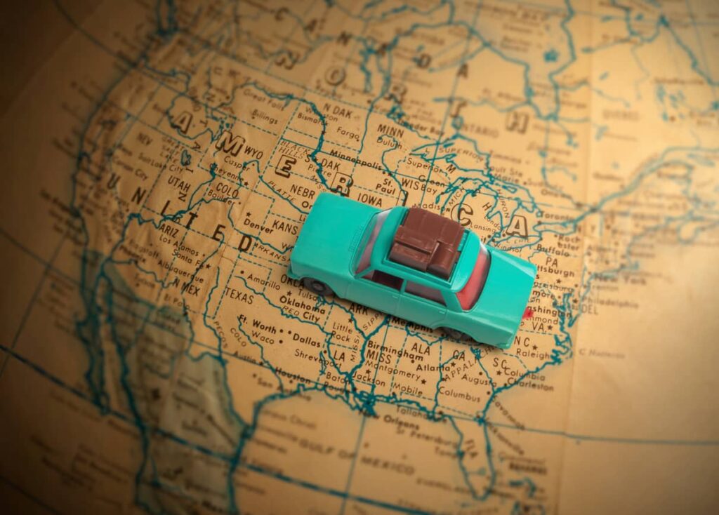 Toy car sitting on top of a map of the United States.